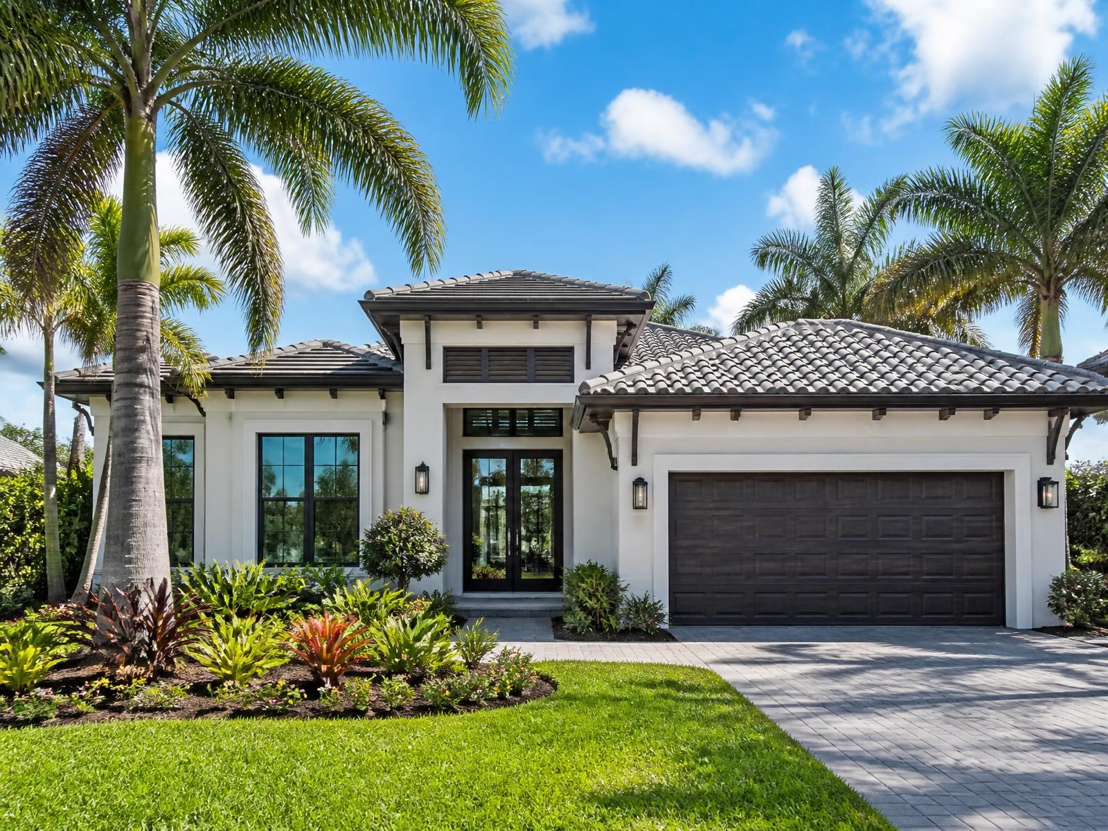 Modern Florida home with a tile roof, palm trees and tropical landscaping